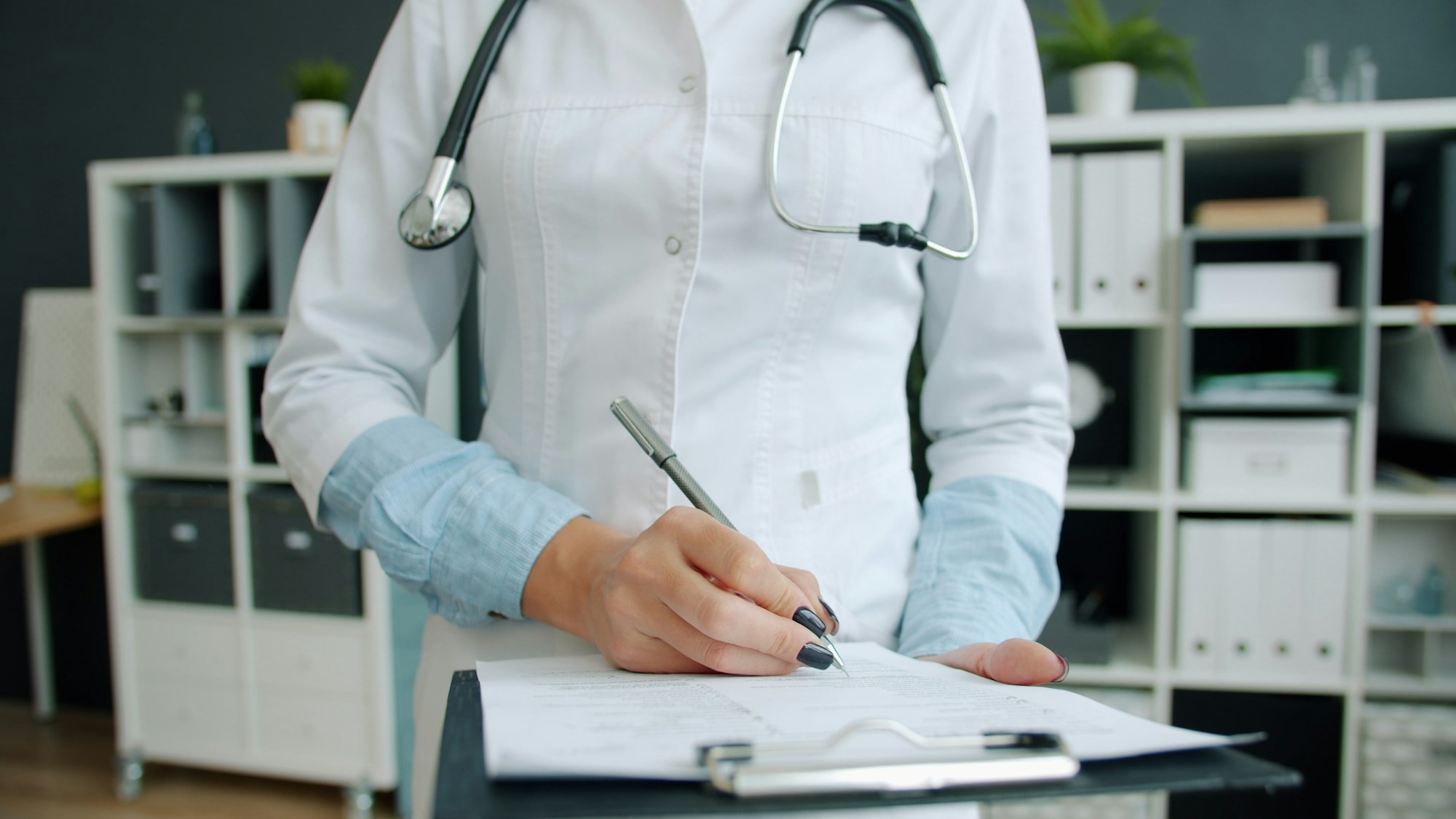 Clinician filling out a patient intake form on a clipboard